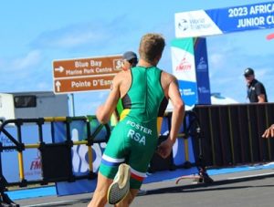 With the sign for Blue Bay, Mauritius, in the background, Nathan Foster charges towards home on the running leg of the 2023 African Triathlon Sprint Championships.